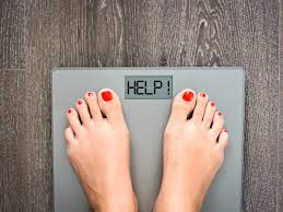 Image of feet standing on scales. Scales spell HELP! in display.