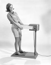 Black and white image of woman using vibrating belt machine