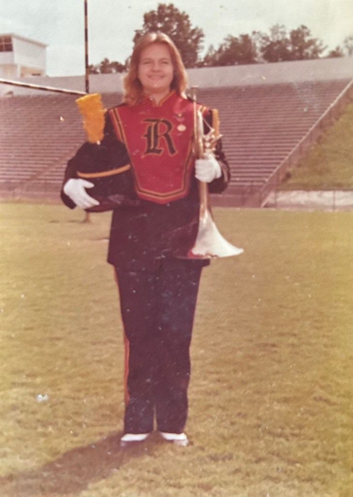 Image of band student Ugena Whitlock posing with mellophone in band uniform, 1977.